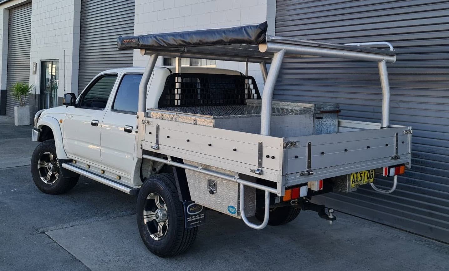 An aluminium drop-side tray with rack and awning on a Hilux