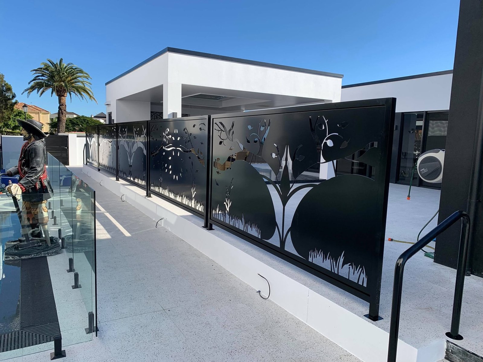 Laser-cut decorative screens installed around a poolside courtyard