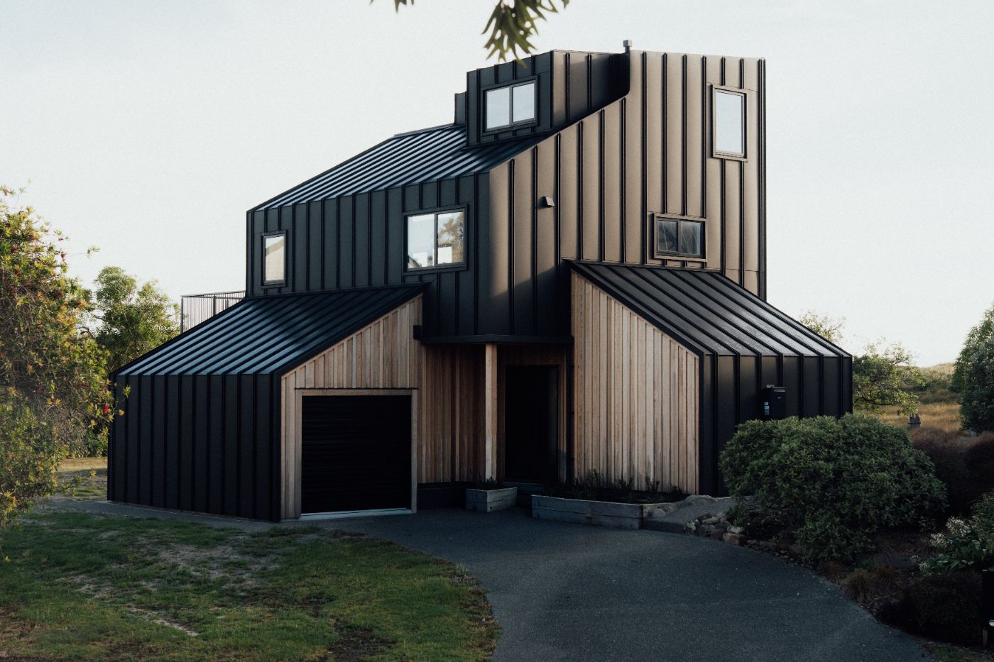 The Bowentown home at dusk, standing-seam cladding and cedar battens