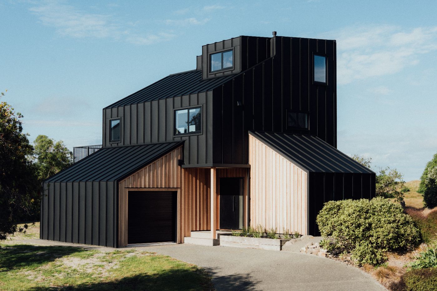 A black standing-seam coastal home clad by Linked Group at Bowentown