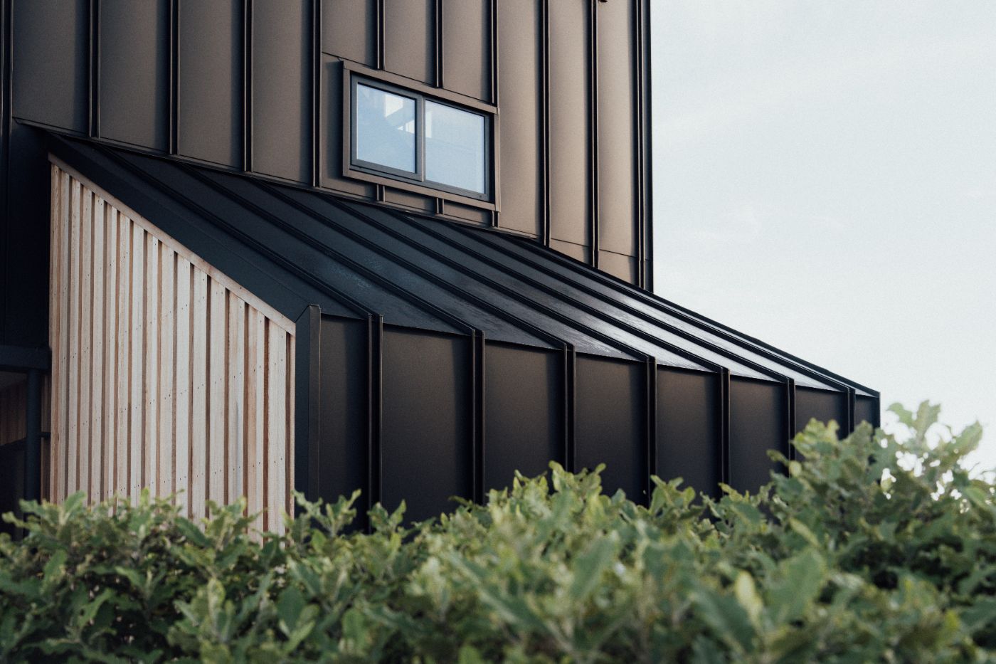 Standing seam meets cedar batten cladding at the garage junction