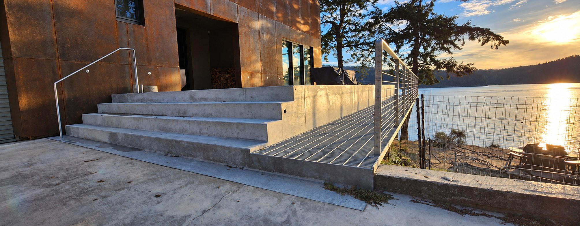 Steel stairs and a cable-rail deck looking out over the water on Mayne Island