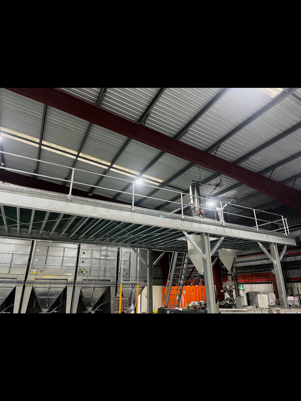 A galvanised structural steel walkway and handrail installed inside an industrial plant