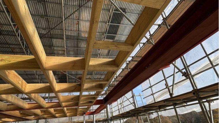 Timber roof trusses going in alongside structural steelwork